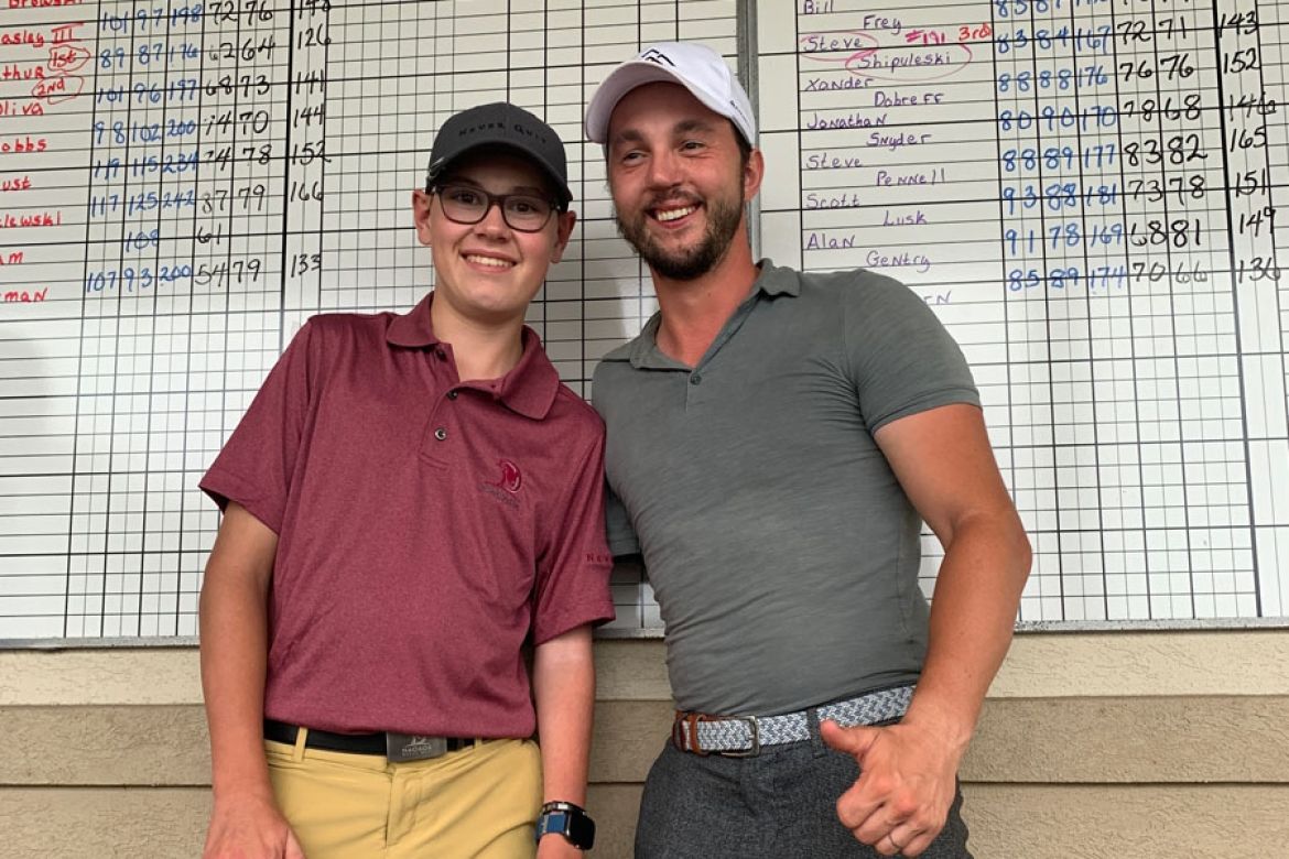 PGA member Alex Fourie works with a fellow physically challenged golfer.